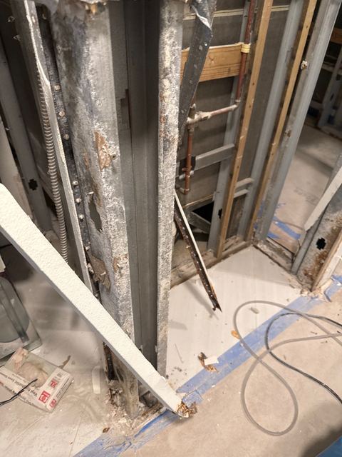 Mold-stained steel wall studs in a stripped wall, and the same studs after cleaning.